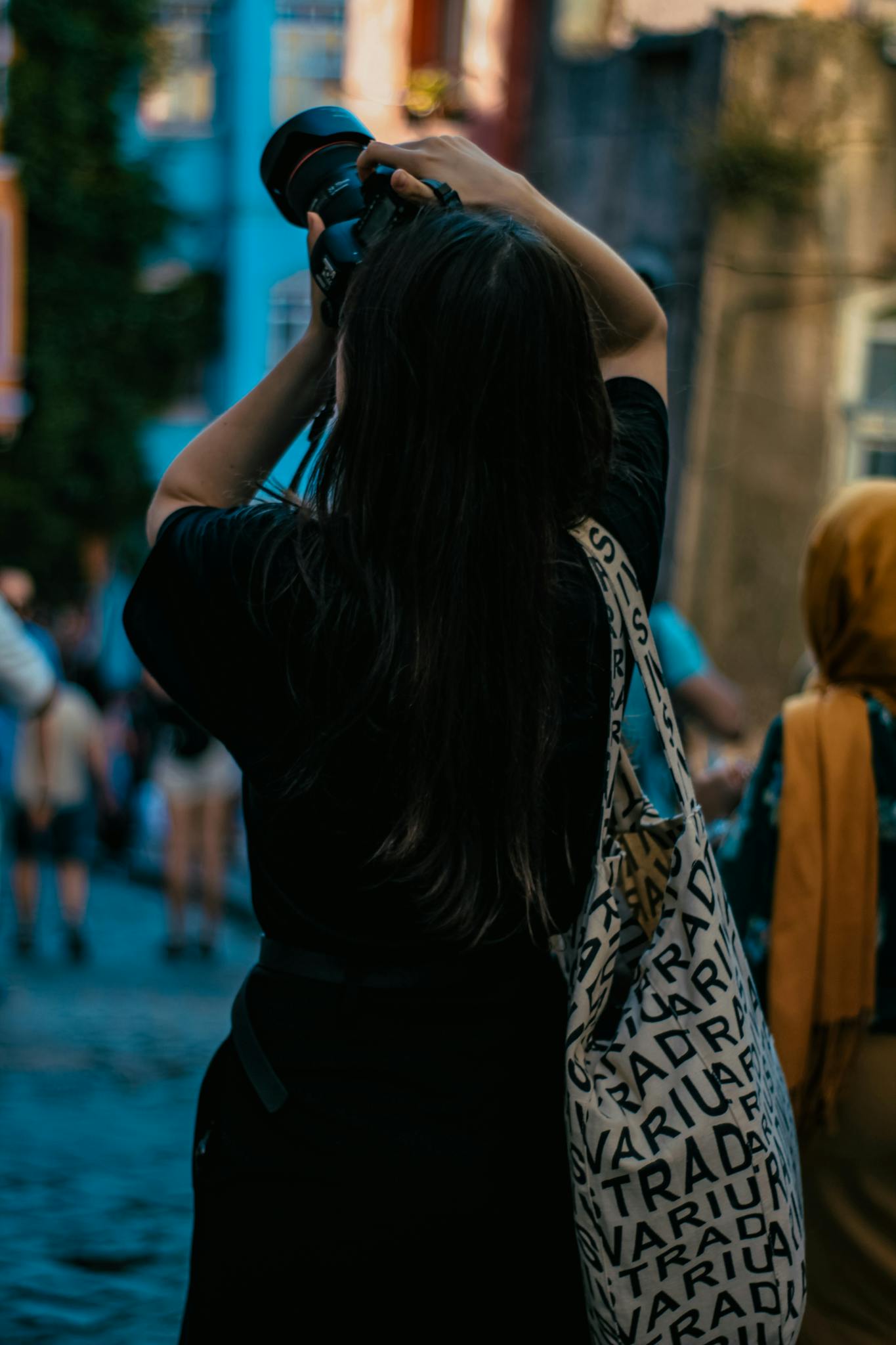 Back view of a woman taking photos in the streets of Istanbul. Urban exploration vibe.